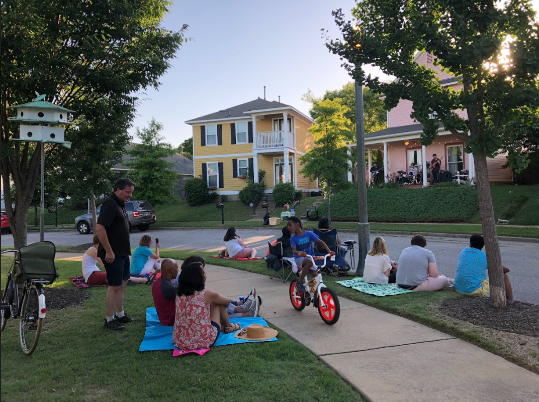 A young boy rides his bike on the path at Uptown Park as his parents and neighbors enjoy the show. (Cole Bradley)