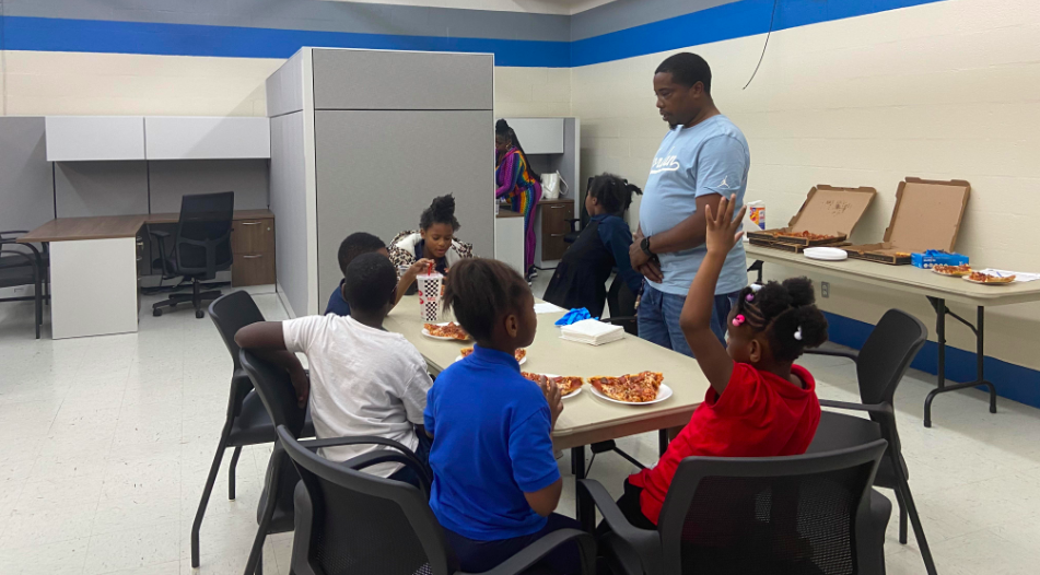 Memphis native and community mentor Casio Montez checks in with a group of children during lunch.